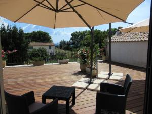 un patio con 2 sillas y una sombrilla en Le Bastidon de CUCURON, en Cucuron