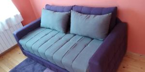 a blue couch with two pillows on it in a room at Apartman Đoković in Višegrad