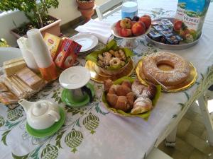 a table with a breakfast of pastries and bread on it at La Castellese in Aci Castello
