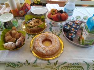 a table topped with plates of food and pies at La Castellese in Aci Castello