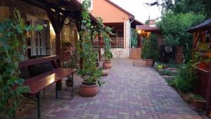 a brick walkway with a bench and potted plants at Főczény Pince és Vendégház in Verpelét