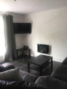 a living room with a couch and a coffee table at 5 Shell Hill Mews in Coleraine
