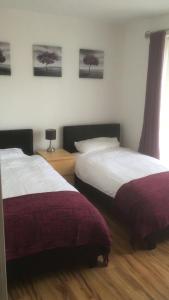 two beds in a hotel room with two bedsskirts at 5 Shell Hill Mews in Coleraine