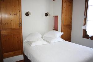 a bedroom with a white bed with two pillows at La Marjolaine in Juan-les-Pins