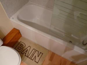 La salle de bains est pourvue d'une baignoire et de toilettes. dans l'établissement Le Petit Grenier, à Bayeux