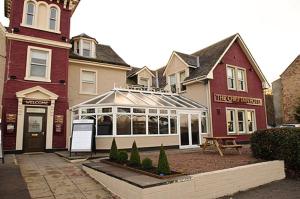 un edificio con un banco delante de él en Chieftain Hotel, en Inverness