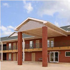 a large brick building with two brick pillars at Homegate Inn in Louisville