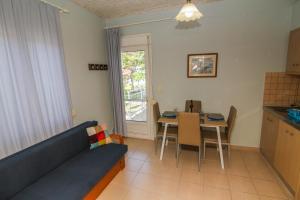 a living room with a blue couch and a table at Studios Avra in Skala Rachoniou