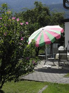 a patio with a colorful umbrella and two chairs at Ferienhaus-Loidl in Bad Ischl