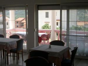 a dining room with tables and chairs and a balcony at Pension Antonia in Baška