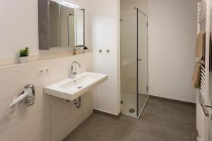 une salle de bain avec lavabo et douche dans l'établissement Komfort-Ferienwohnung Wellenbrecher by Meer-Ferienwohnungen, à Olpenitz 25 autres photos