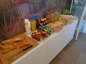 un buffet con pan y otros alimentos en una mesa en Maison Jonela, en Châteauneuf-du-Faou