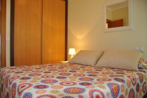 コティージョにあるCotillosandのベッドルーム1室(カラフルな毛布付きのベッド1台付)