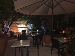 a restaurant with tables and chairs and an umbrella at La Marjolaine in Juan-les-Pins