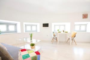 uma sala de estar branca com uma mesa e cadeiras em MalagaUrbanRooms - Central Suites em Málaga