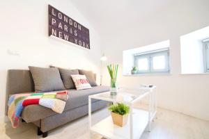 uma sala de estar com um sofá e uma mesa de vidro em MalagaUrbanRooms - Central Suites em Málaga