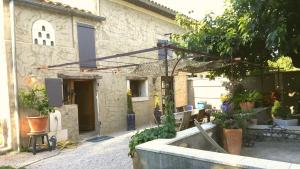 a house with a courtyard with a tub of plants at Mas Ribou in Barbentane