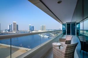 a balcony with chairs and a view of the water at Waterfront One Bedroom Downtown in Dubai