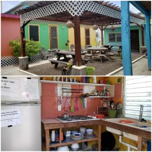 een keuken met een tafel en een koelkast en een huis bij Sea n sun Guest House in Caye Caulker