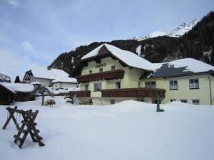 ein großes Gebäude mit Schnee auf dem Boden in der Unterkunft Gästehaus Marianne Baier in Zederhaus