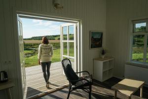 a woman is walking out of a door at Hótel Lækur in Hella