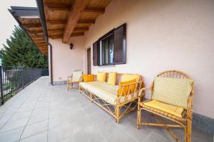 d'une terrasse avec des chaises, une table et une fenêtre. dans l'établissement Villetta maison hélène, à Aoste