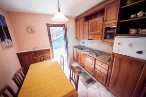 a kitchen with a table and a kitchen with a refrigerator at Villetta maison hélène CIR n 0391 in Aosta