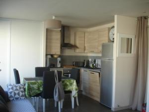 a kitchen with a refrigerator and a table with chairs at Studio Centre Ville Office De Tourisme in Bayonne