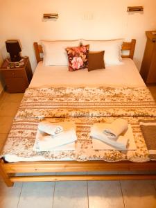 a bed with two sheets and two books on it at AVRA Apartments in Therma