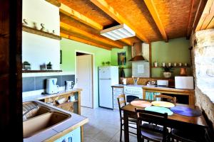 cocina con fregadero y mesa con sillas en Le Vieux Séchoir en Miers