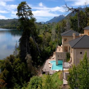 a house with a swimming pool next to a lake at Luma Casa De Montaña in Villa La Angostura