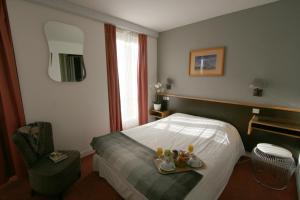 a hotel room with a bed with a tray of food at Denfert-Montparnasse in Paris