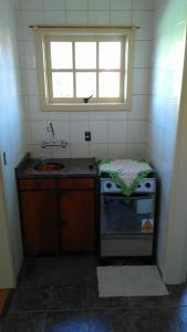 una pequeña cocina con fregadero y ventana en Apartamento p/ 4 pessoas em Gramado/RS, en Gramado