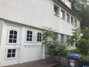 ヴッパータールにある1 Zimmer Wohnung mit Küche und Bad in Wuppertal Ferienwohnungの白い家の白いガレージドア