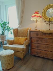 a living room with a chair and a dresser at Light, Spacious Apartment in the Heart of Belgrade in Belgrade