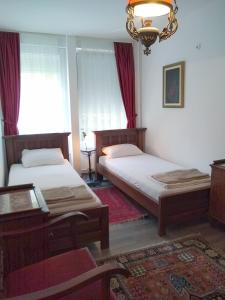 een slaapkamer met 2 bedden en een kroonluchter bij Light, Spacious Apartment in the Heart of Belgrade in Belgrado