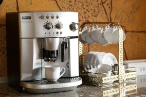 a coffee maker on a counter with cups and dishes at Oli House in Alba Iulia