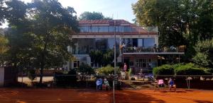 ein Gebäude mit Tennisspielern auf einem Tennisplatz in der Unterkunft Sport Pension Cibulka in Prag