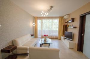 een woonkamer met een witte bank en een tv bij Apartment "Bella" in Gabrovo
