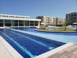 una gran piscina frente a un edificio en Flat Clube Porto Galinhas en Porto De Galinhas