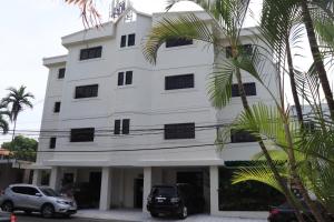 ein weißes Gebäude mit davor geparkt in der Unterkunft Esmeralda in Santo Domingo
