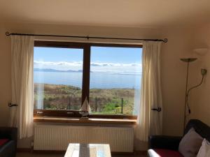 a room with a large window with a view of the ocean at Rona in Aultgrishin