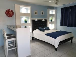 Schlafzimmer mit einem Bett, einem Schreibtisch und Fenstern in der Unterkunft Esmeralda in Santo Domingo