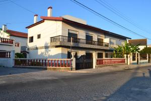 a white house with a red fence in front of it at Offshore Rustic House in Peniche