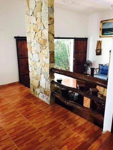 sala de estar con chimenea de piedra y suelo de madera. en La cabañita, en Tuxtla Gutiérrez