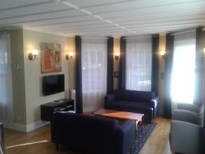 a living room with a couch and a table and a tv at Le Gîte Du Coteau in Lyster