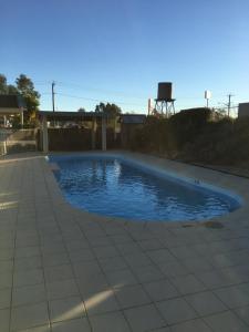 a swimming pool with blue water in a backyard at Tuckerbox Motor Inn in Gundagai