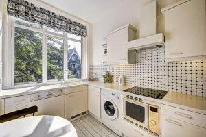 una cocina con electrodomésticos blancos y una ventana en Hampstead Stylish Apartment Brilliant Location en Londres