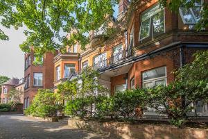 un edificio de ladrillo con arbustos delante de él en Hampstead Stylish Apartment Brilliant Location en Londres