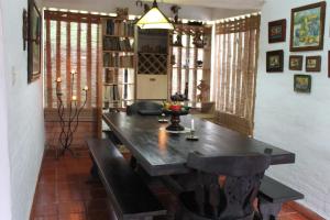 a dining room with a wooden table and benches at Hermosa Finca "Rancho 4Js" in La Cumbre